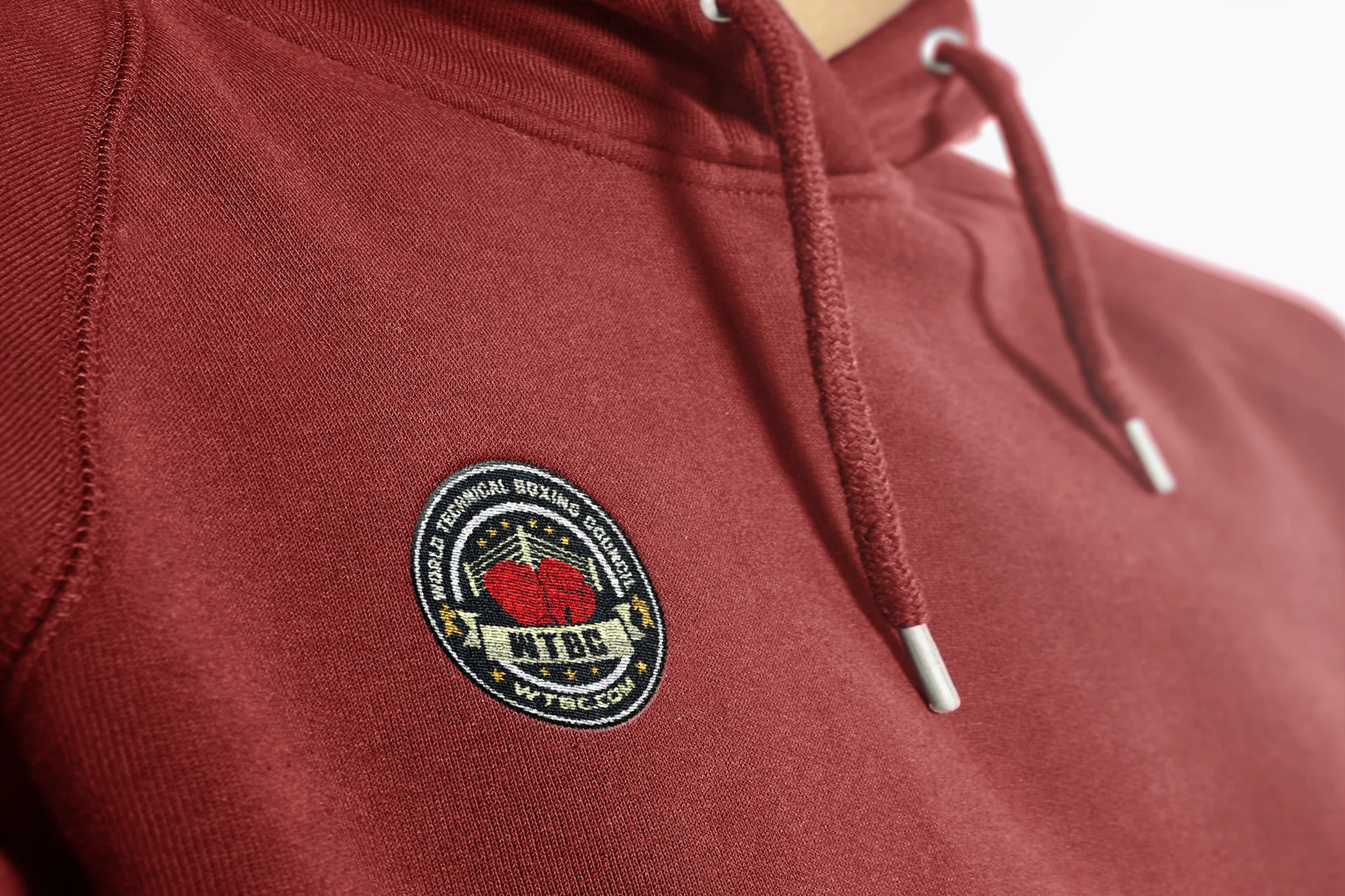 Embroidered WTBC badge on a maroon hoodie